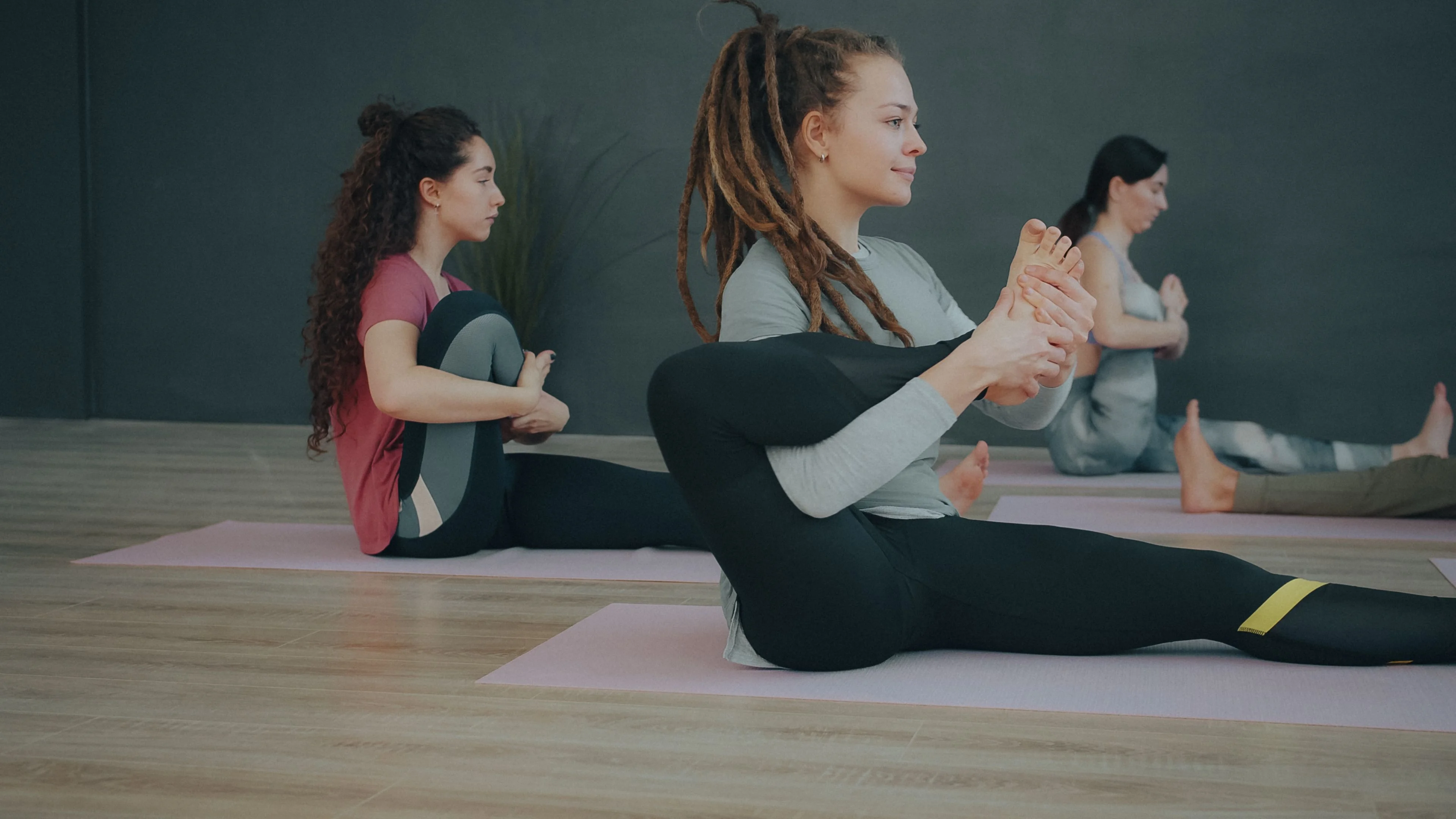Two women stretching together on studio mats