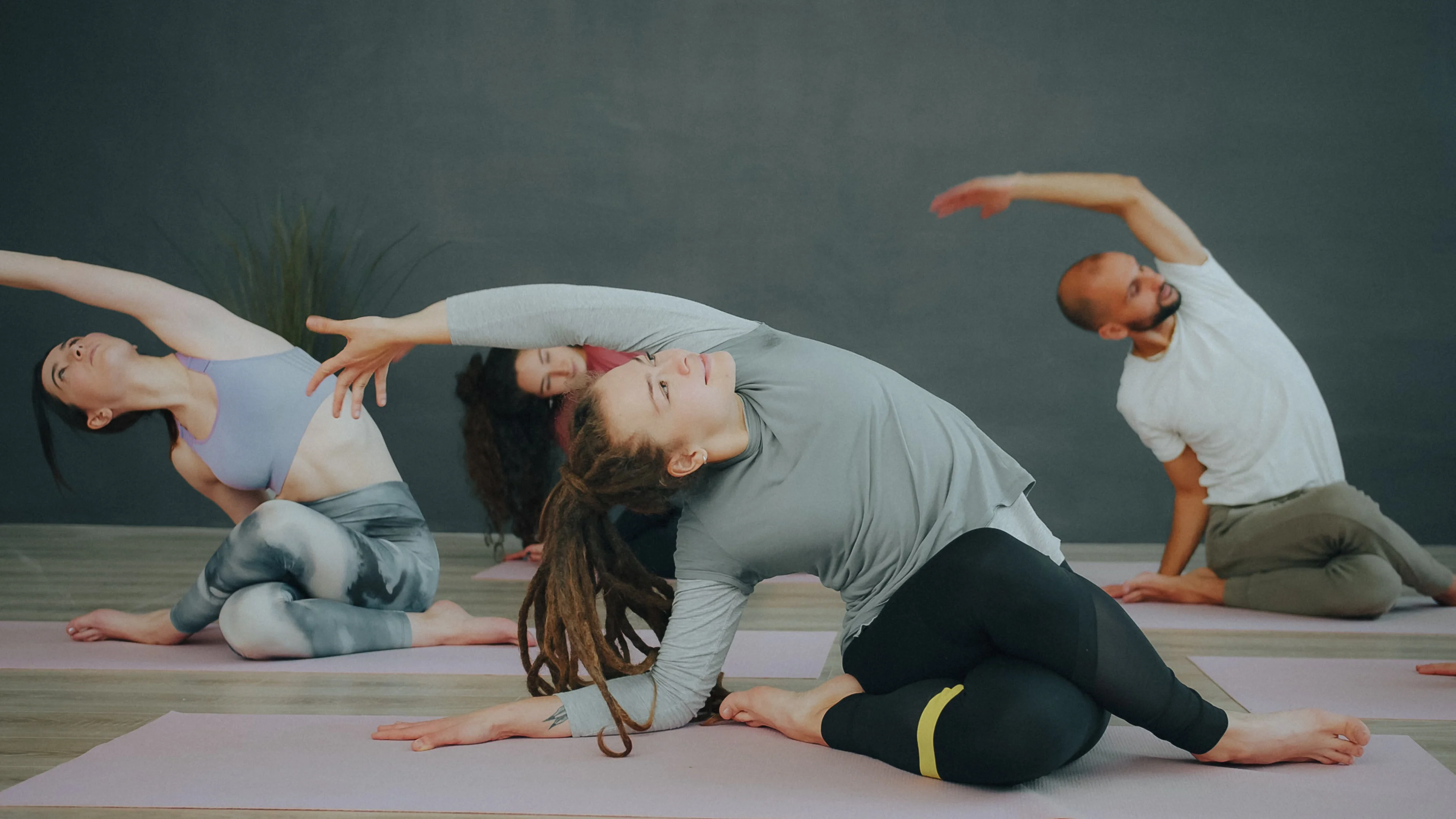 Yoga class holding a standing side bend on mats