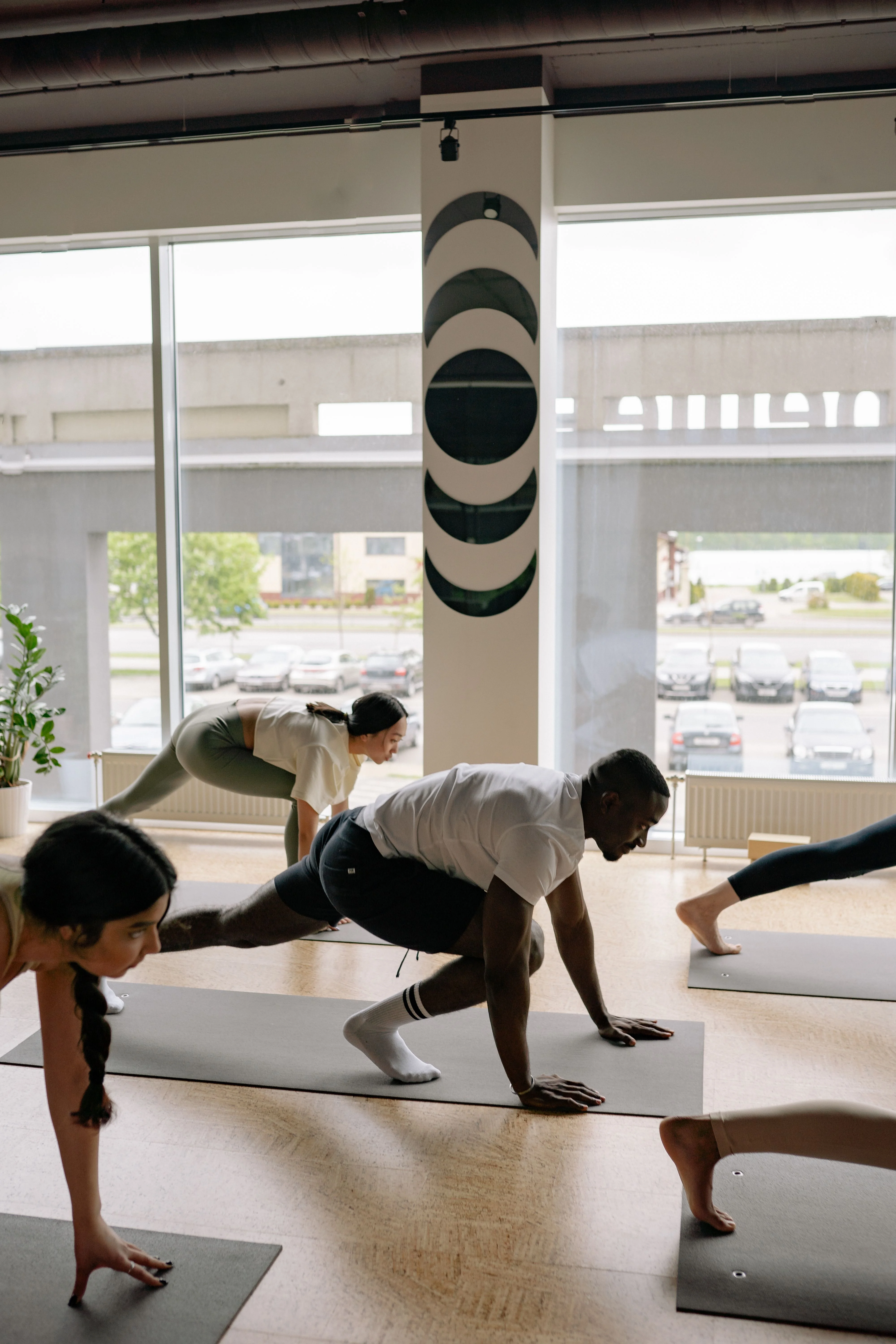 Two people holding a plank in a daylight studio
